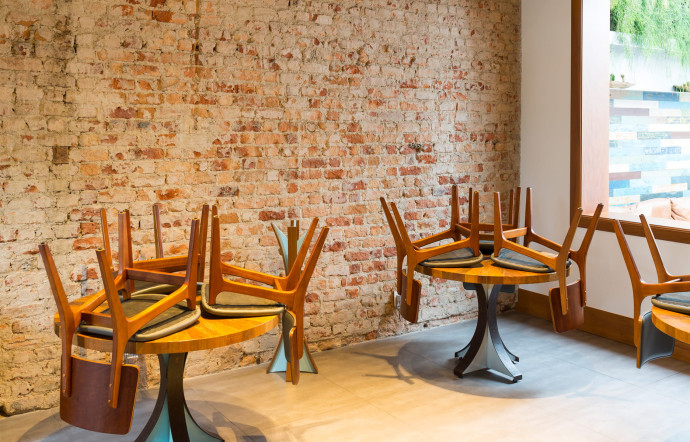 Le restaurant du chef Rafael Costa e Silva offre aux clients un premier espace sous une belle charpente, avec mur de pierres et mobilier en bois.
